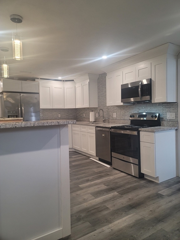 19 Saugus Avenue, Unit 2 Saugus, MA 01906 - Photo 4 of 13 a kitchen with stainless steel appliances granite countertop a stove top oven a sink and a microwave