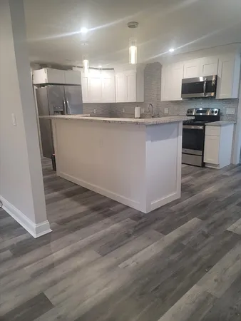 a kitchen with stainless steel appliances granite countertop a sink a stove a refrigerator and cabinets