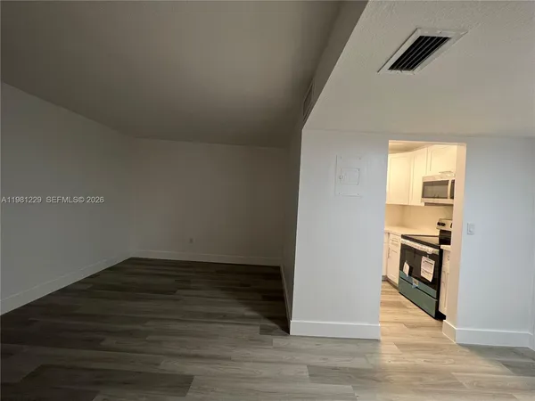 an empty room with wooden floor and a window