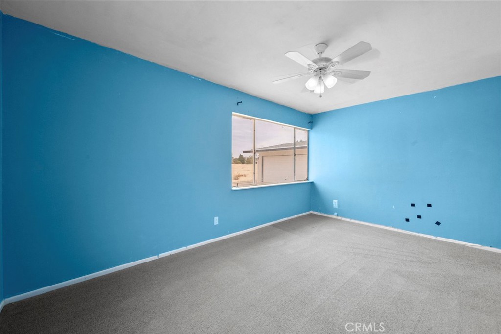 18251 Hiawatha Road Apple Valley, CA 92307 - Photo 48 of 58 an empty room with a window and a ceiling fan