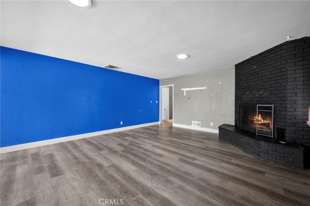 18251 Hiawatha Road Apple Valley, CA 92307 - Photo 54 of 58 a view of empty room with wooden floor and fireplace