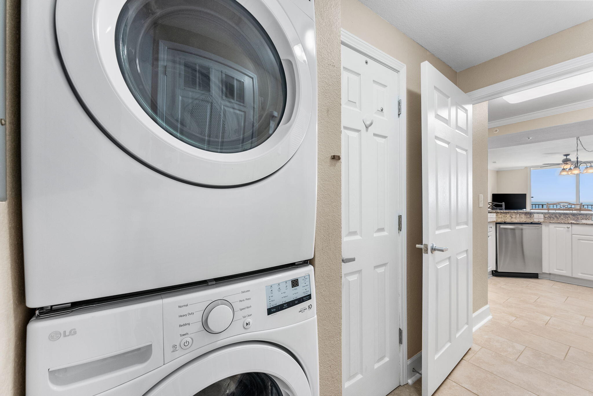 16819 Front Beach Road, Unit 405 Panama City Beach, FL 32413 - Photo 25 of 48 a view of washer and dryer with kitchen in the background