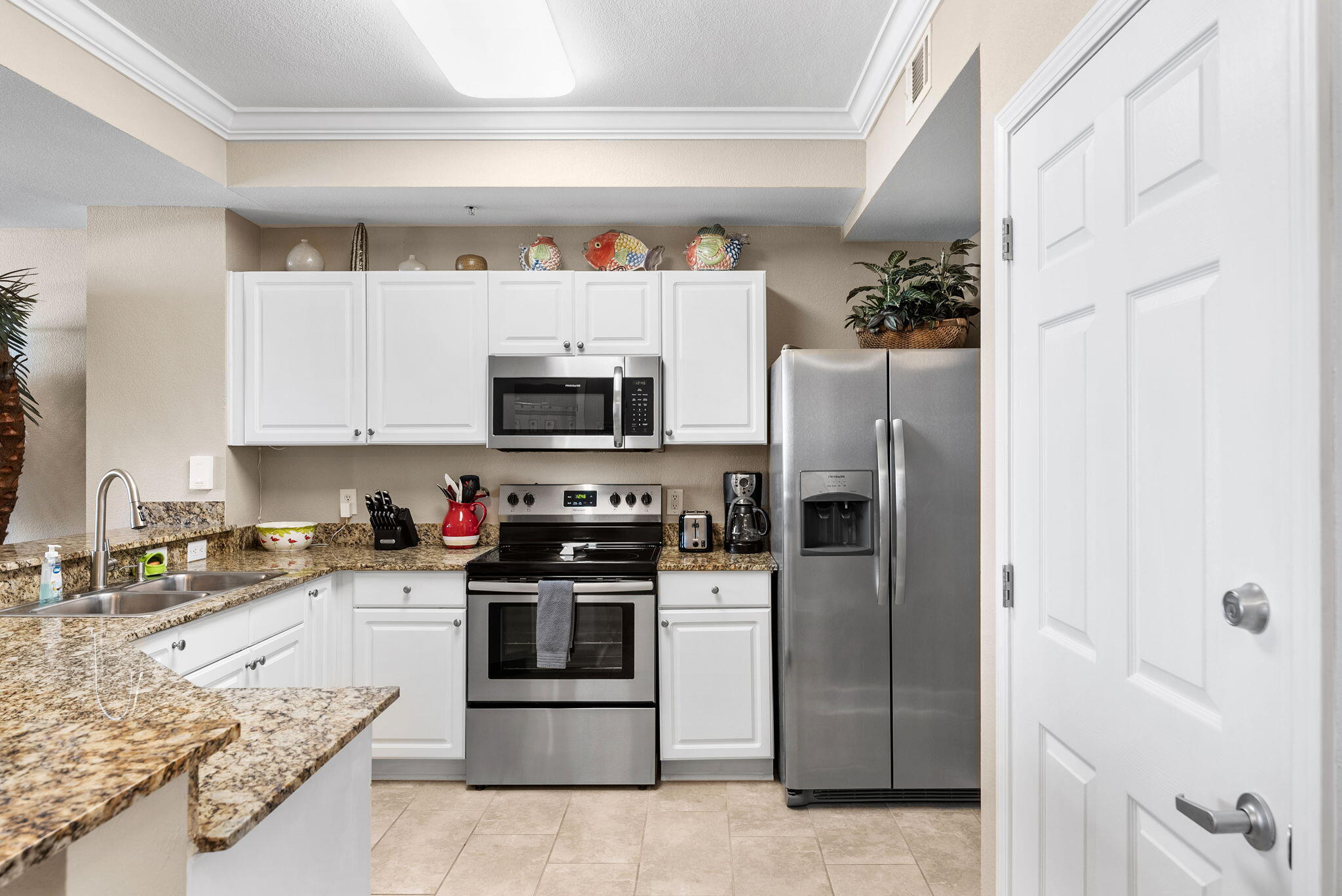 16819 Front Beach Road, Unit 405 Panama City Beach, FL 32413 - Photo 6 of 48 a kitchen with stainless steel appliances granite countertop a refrigerator and a stove