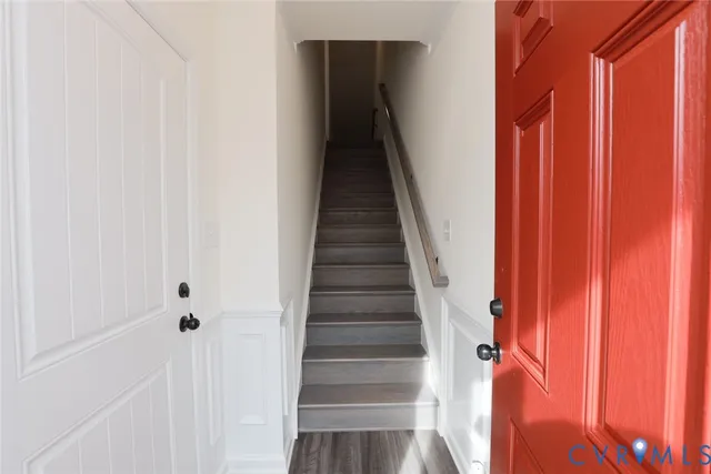a view of staircase with wooden floor and white walls