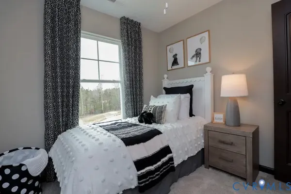 a bedroom with a bed and a night stand next to a window