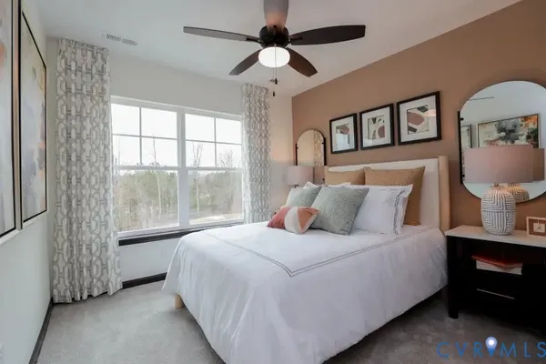 a bedroom with a large bed and a chandelier fan