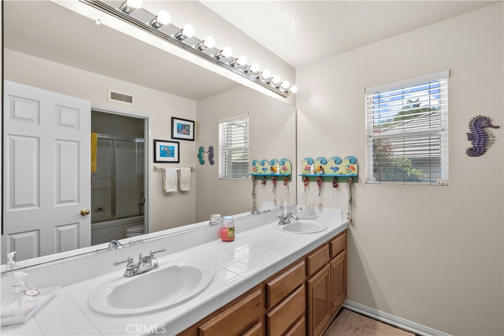 28834 Rock Canyon Drive Saugus, CA 91390 - Photo 24 of 58 a bathroom with a double vanity sink and a mirror