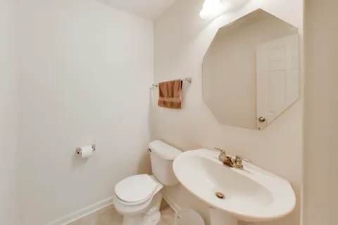a bathroom with a sink mirror and toilet