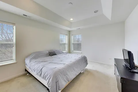 a bedroom with a bed and flat tv screen on the dresser