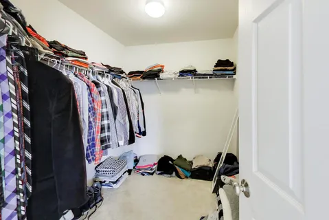 a view of walk in closet with clothes and shoes