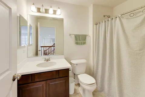 a bathroom with a sink a toilet and shower curtain