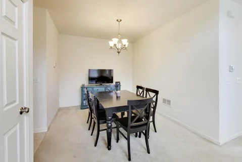 a view of a dining room with a table and chairs