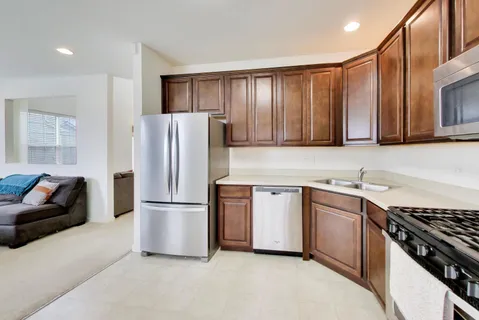 a kitchen with stainless steel appliances granite countertop a refrigerator stove and sink