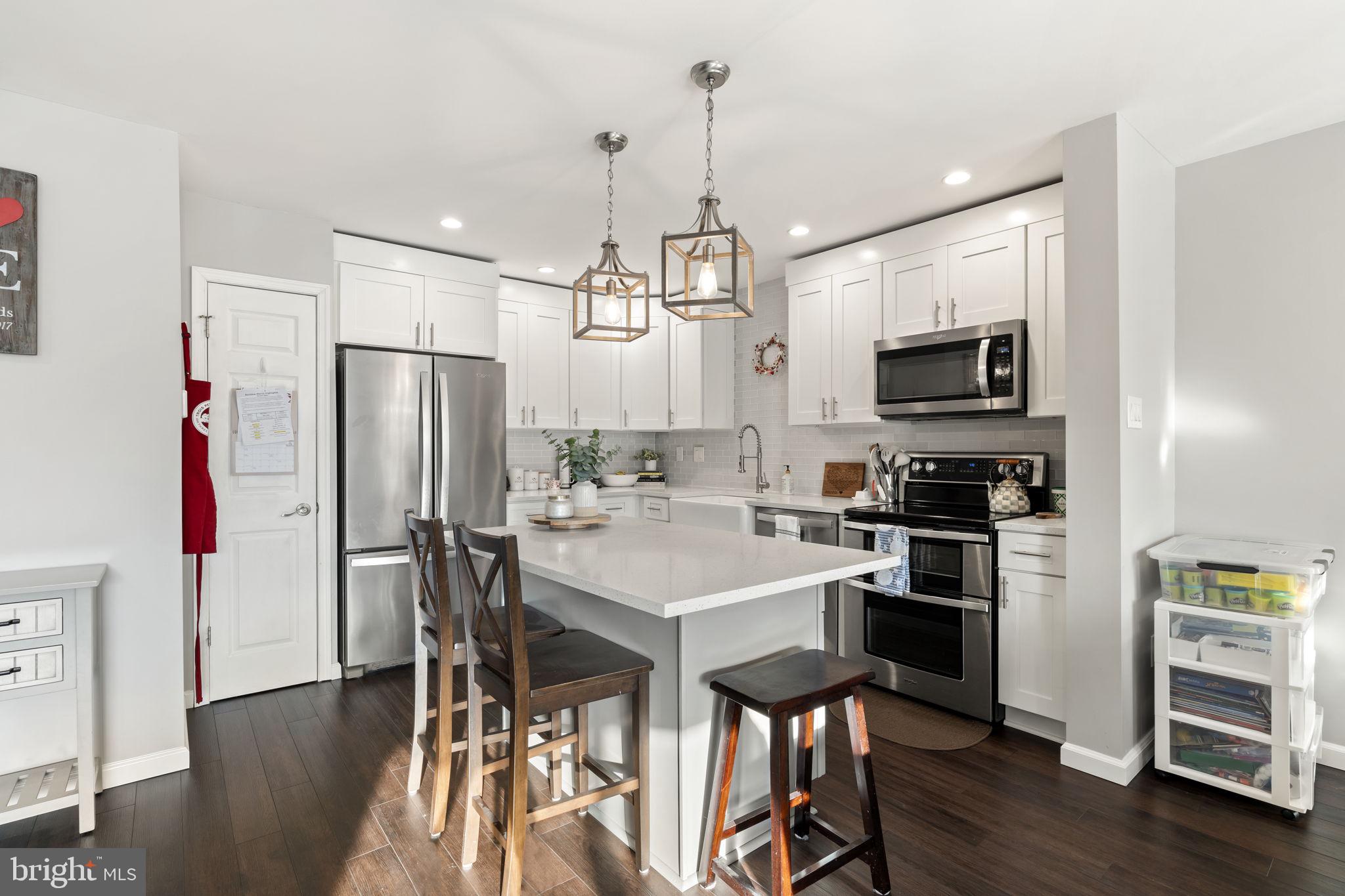19 Chateau Circle, Unit 29 Chesterbrook, PA 19087 - Photo 8 of 40 a kitchen with stainless steel appliances a dining table chairs refrigerator and microwave