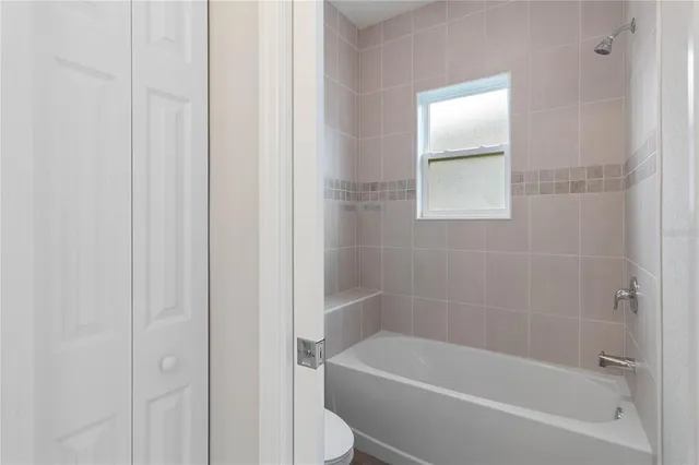 an empty room with closet and a hallway