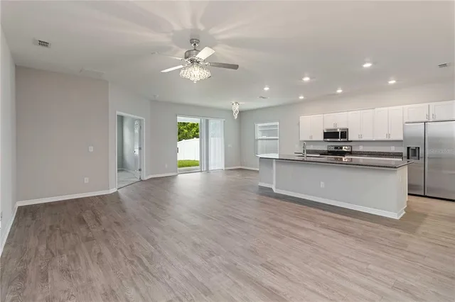 a view of kitchen with kitchen island stainless steel appliances cabinets and wooden floor