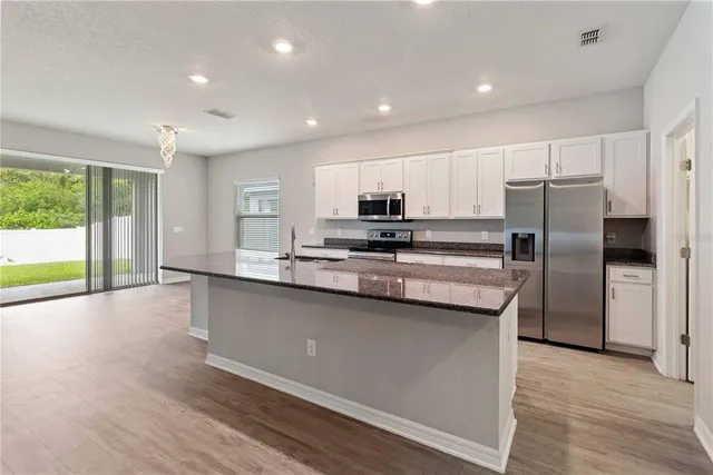 a kitchen with stainless steel appliances a microwave a sink and a refrigerator
