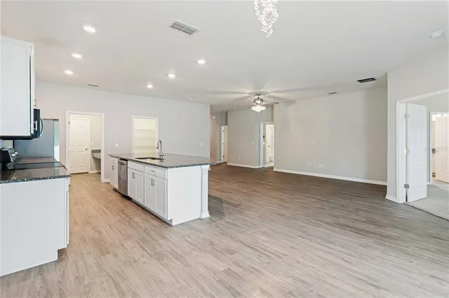 a large kitchen with a lot of counter space and wooden floor