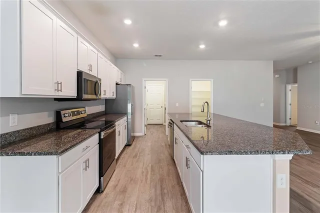 a kitchen with stainless steel appliances granite countertop a sink stove and granite counter tops