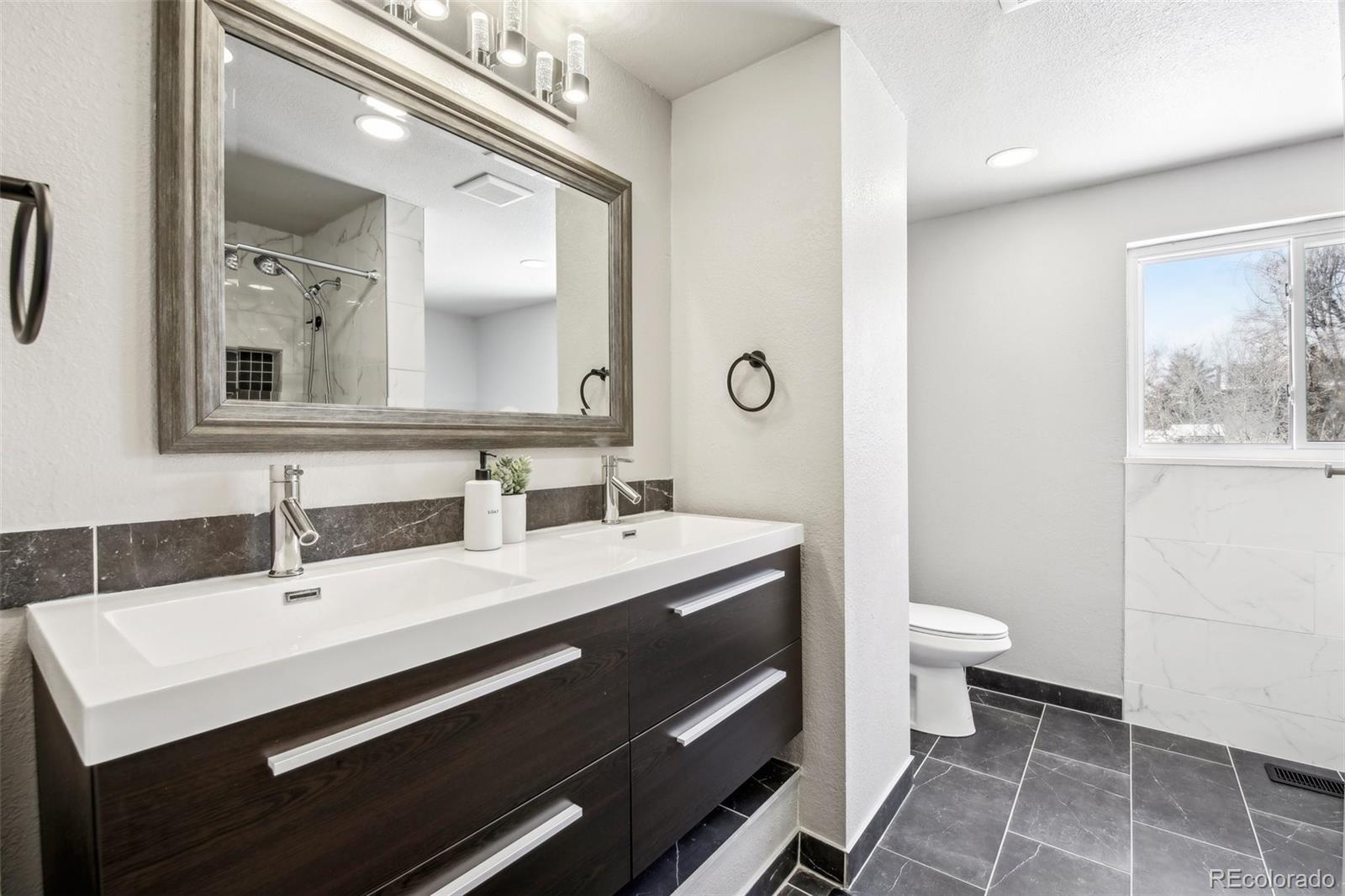 5153 Tucson Way Denver, CO 80239 - Photo 11 of 29 a bathroom with a sink and a mirror with toilet