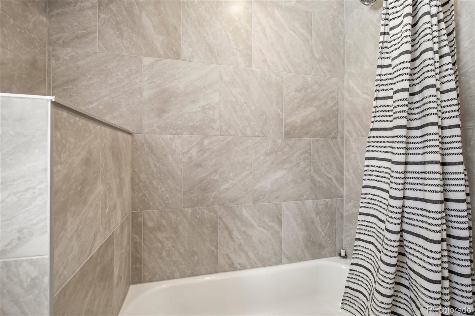 5153 Tucson Way Denver, CO 80239 - Photo 23 of 29 a bathroom with a bathtub and shower