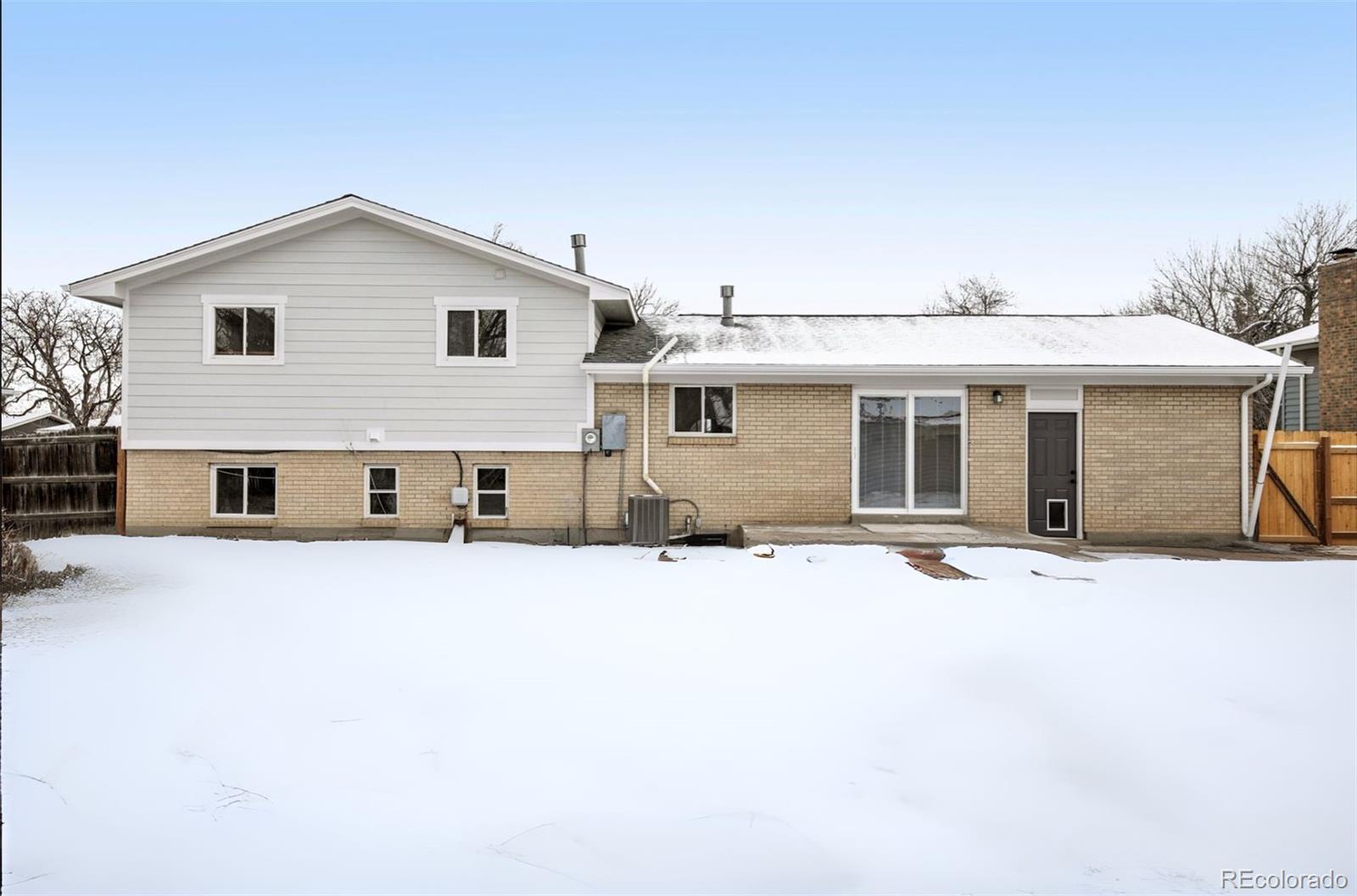 5153 Tucson Way Denver, CO 80239 - Photo 26 of 29 a front view of a house with a yard and garage