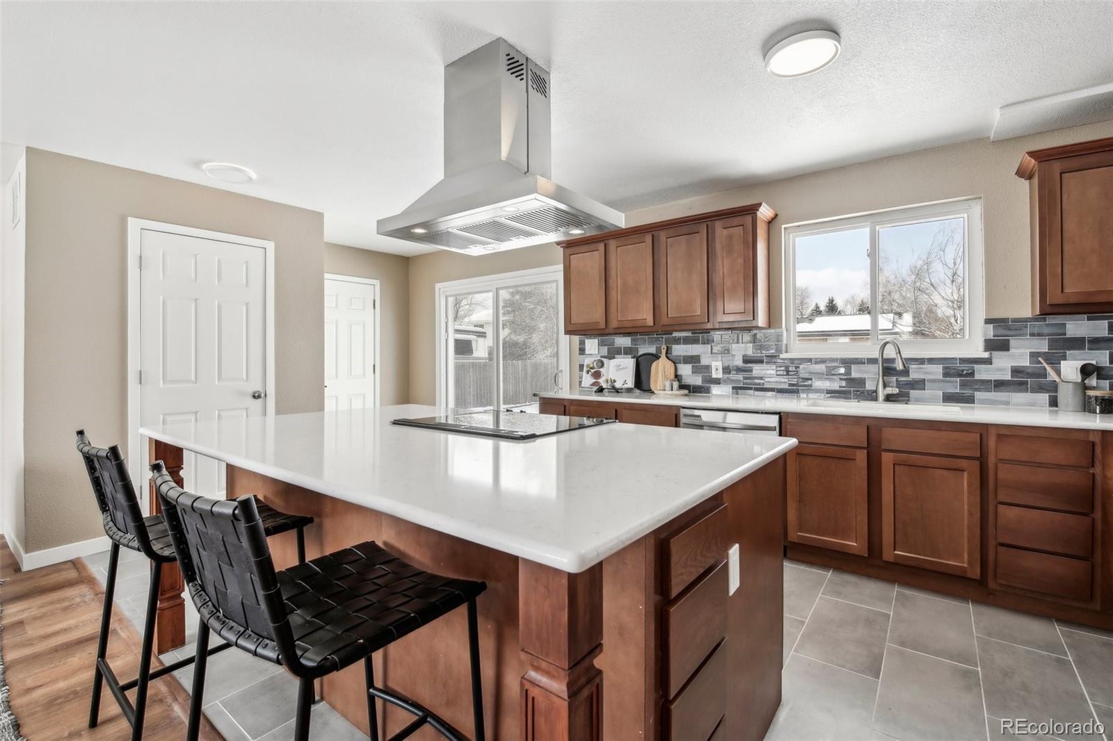 5153 Tucson Way Denver, CO 80239 - Photo 10 of 29 a kitchen with a stove a sink and a refrigerator