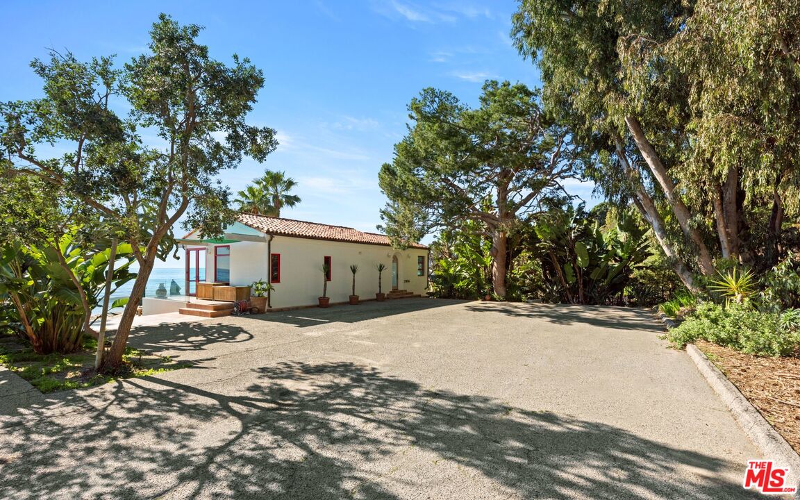 27910 Pacific Coast Highway Malibu, CA 90265 - Photo 11 of 28 a tall yellow house with trees in front of it