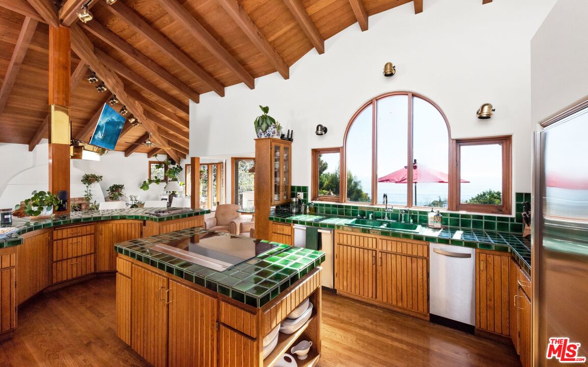 27910 Pacific Coast Highway Malibu, CA 90265 - Photo 21 of 28 a kitchen with stainless steel appliances granite countertop a stove and a view of living room