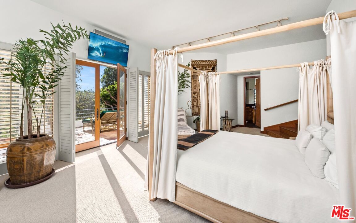 27910 Pacific Coast Highway Malibu, CA 90265 - Photo 25 of 28 a bedroom with a bed a flat screen tv and a large window