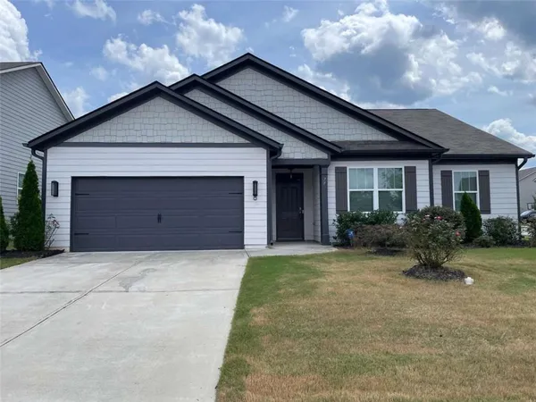 a front view of house with yard and trees around