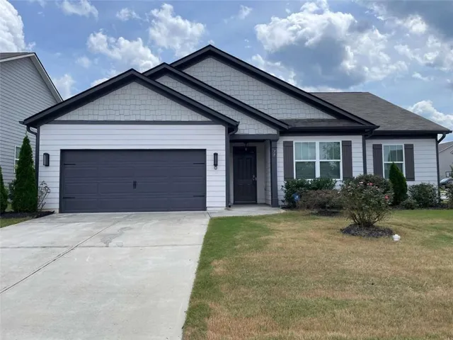 a front view of house with yard and trees around