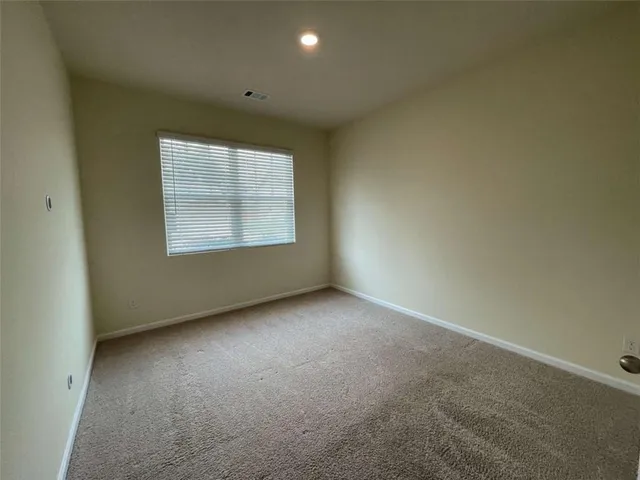 an empty room with a window and a bathroom