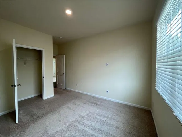 an empty room with an entryway and window