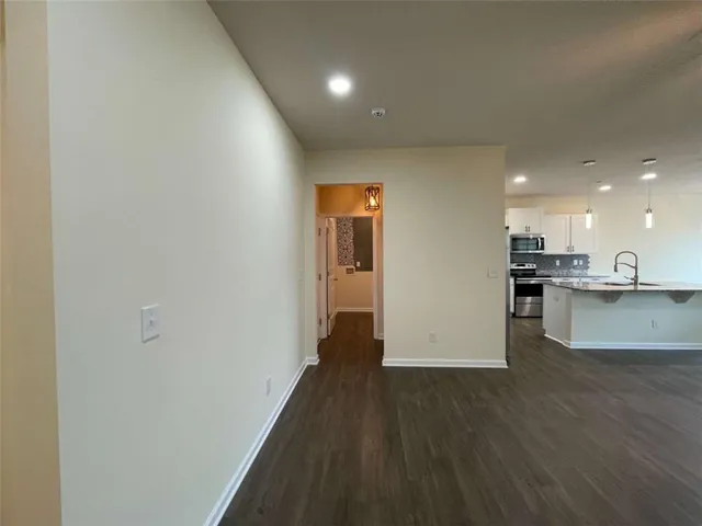 a view of kitchen with refrigerator and wooden floor