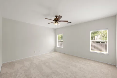 a view of a room with a ceiling fan and a window