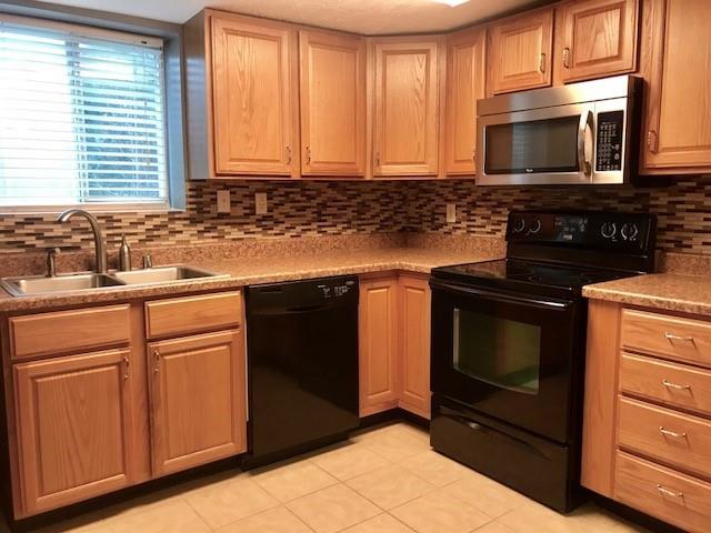 a kitchen with granite countertop a stove microwave and sink