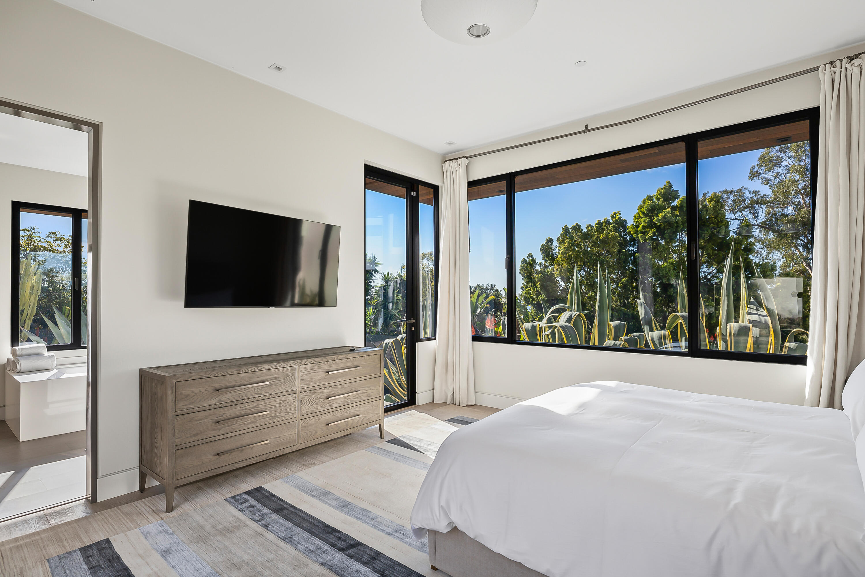 1131 Las Alturas Road, Unit SHARE B Santa Barbara, CA 93103 - Photo 22 of 32 a bedroom with a large bed and a flat tv screen next to a window