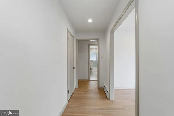 a view of a hallway with wooden floor