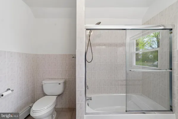 a bathroom with a granite countertop bathtub shower and toilet