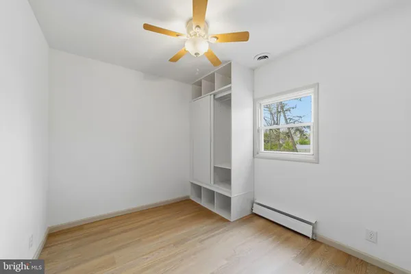 an empty room with windows and fan