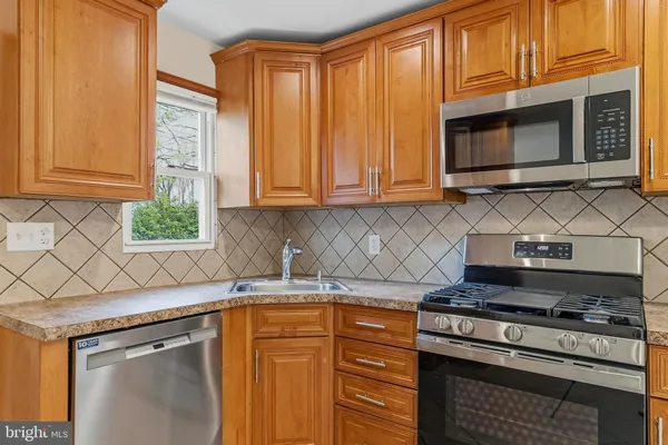 a kitchen with stainless steel appliances granite countertop a stove a microwave and a sink
