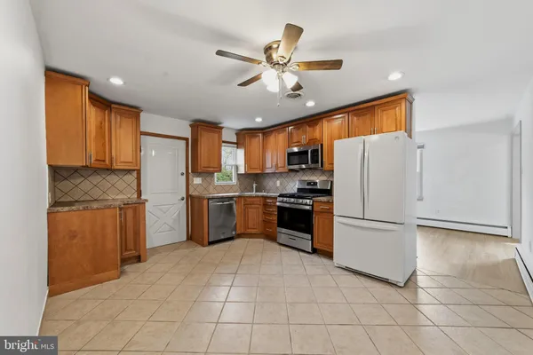 a kitchen with a refrigerator a sink and white cabinets