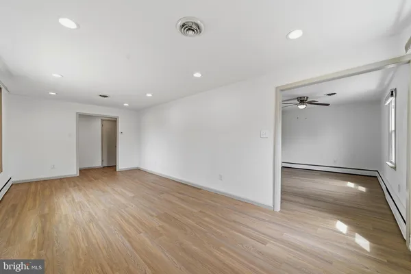 an empty room with wooden floor and a bathroom