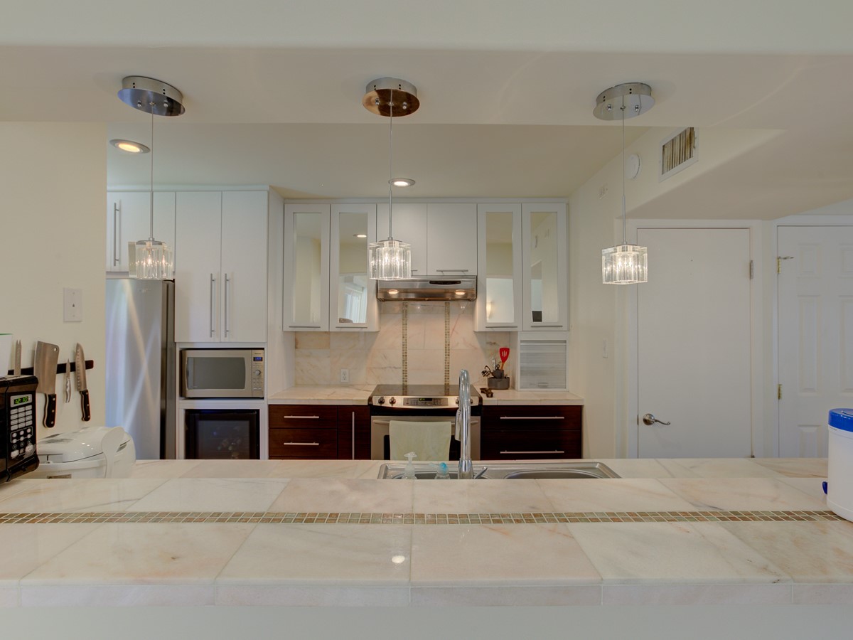 710 Castle Ridge Road, Unit B Austin, TX 78746 - Photo 7 of 27 A well-appointed kitchen features sleek countertops and contemporary pendant lighting.