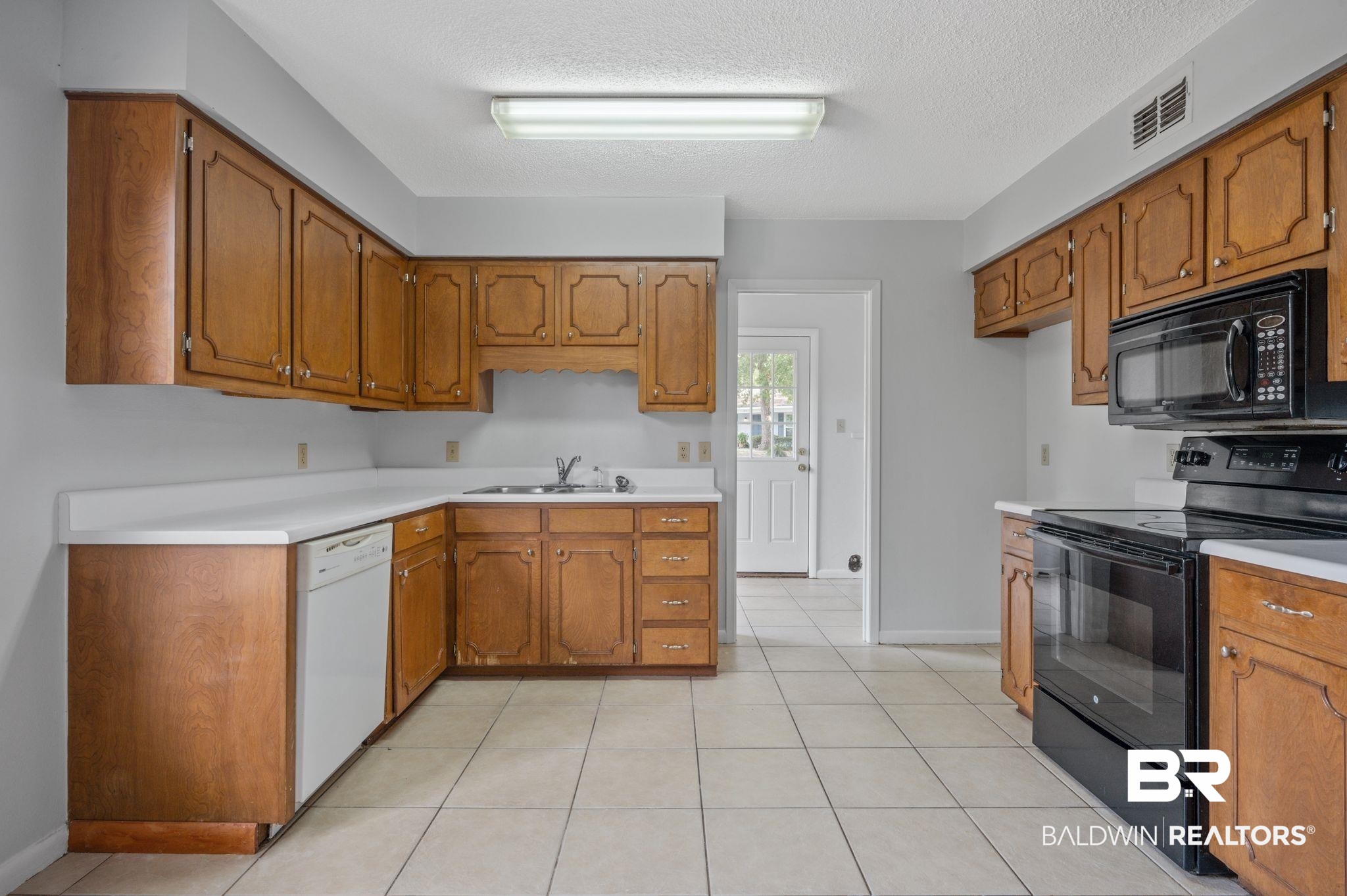 3701 Vista Ridge Drive Mobile, AL 36693 - Photo 11 of 33 Kitchen with a textured ceiling, light tile patterned floors, black appliances, and sink