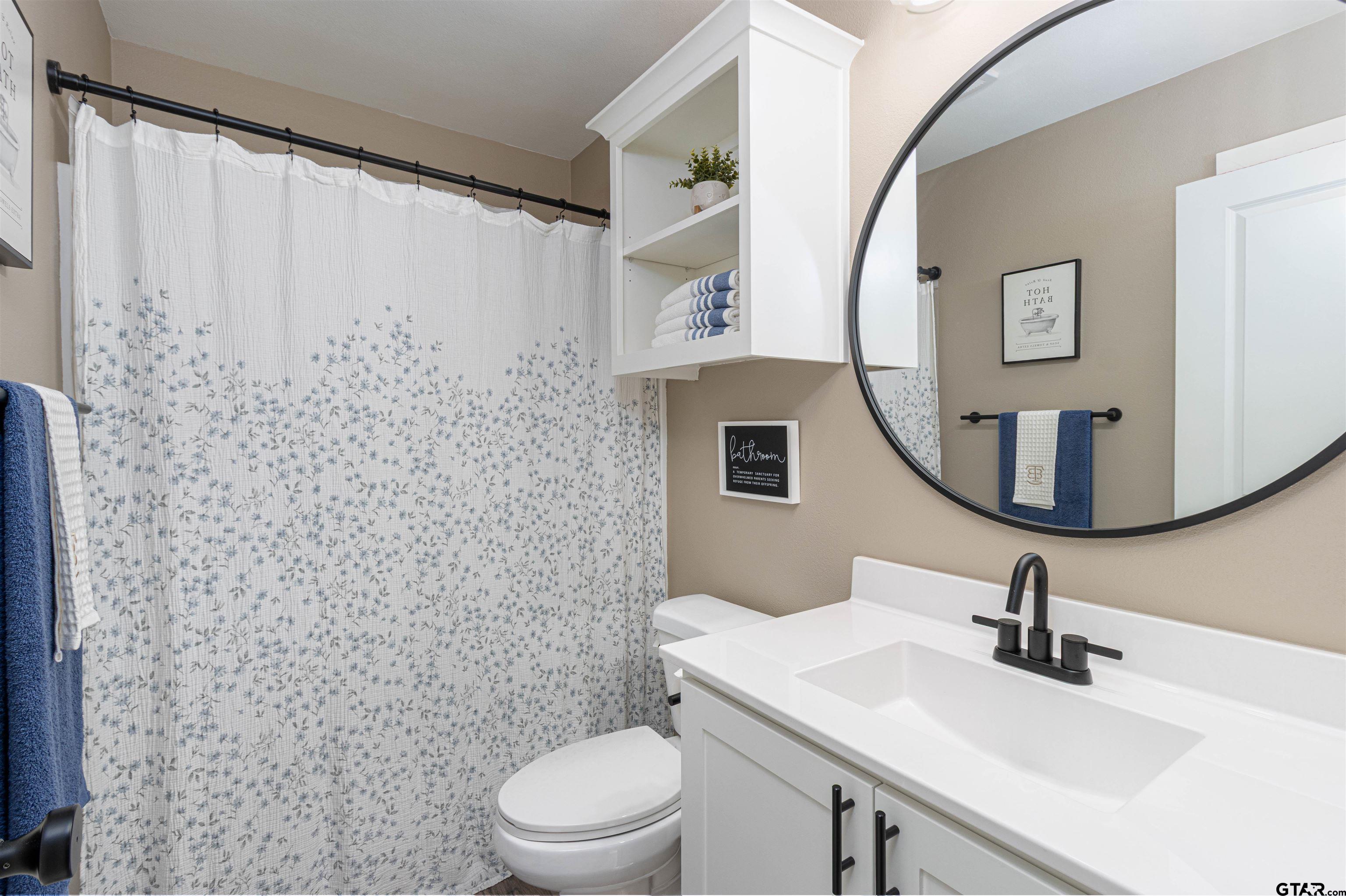 16210 Crossing Circle Lindale, TX 75771 - Photo 16 of 22 a bathroom with a toilet sink and mirror