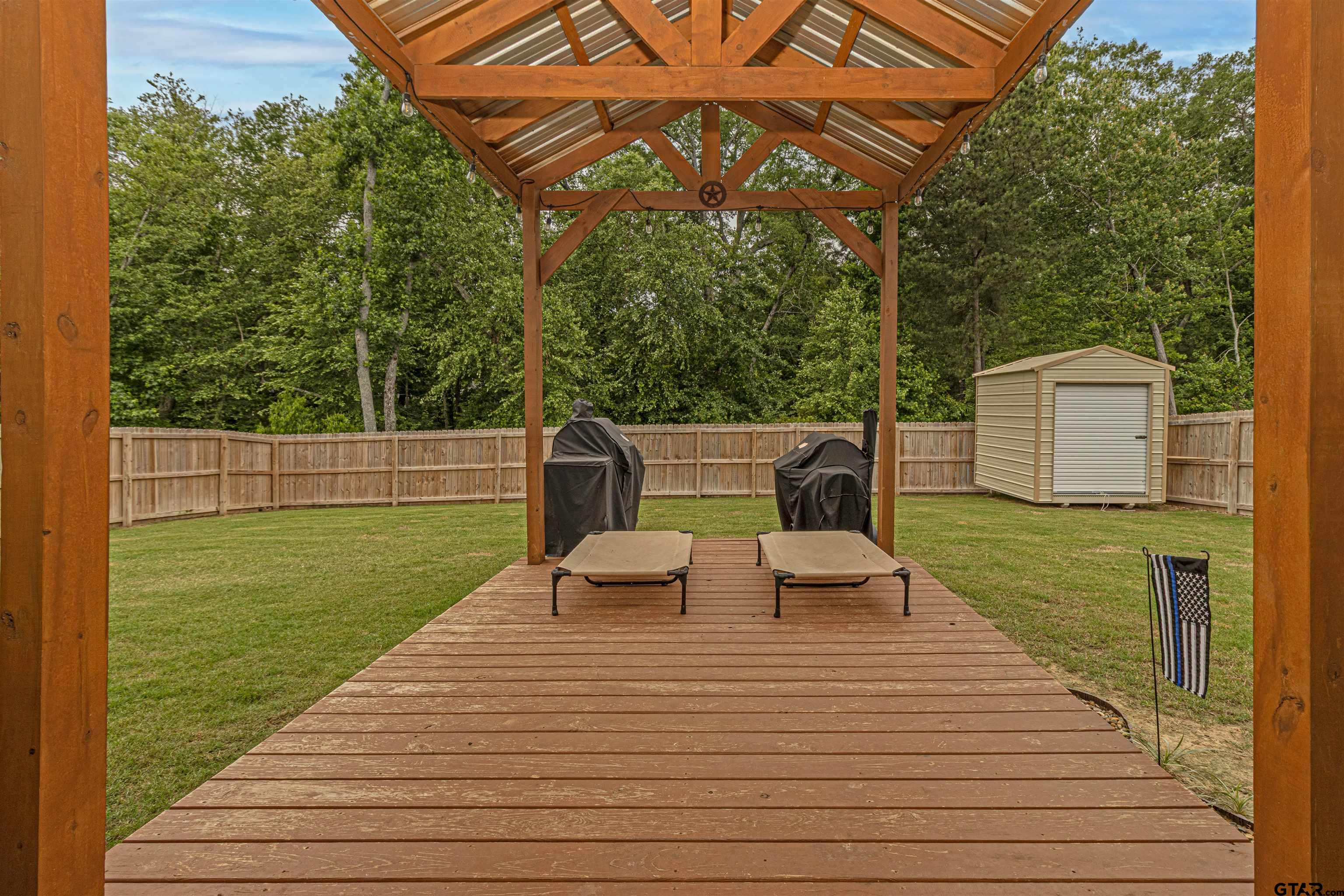 16210 Crossing Circle Lindale, TX 75771 - Photo 19 of 22 a view of a wooden deck and a backyard