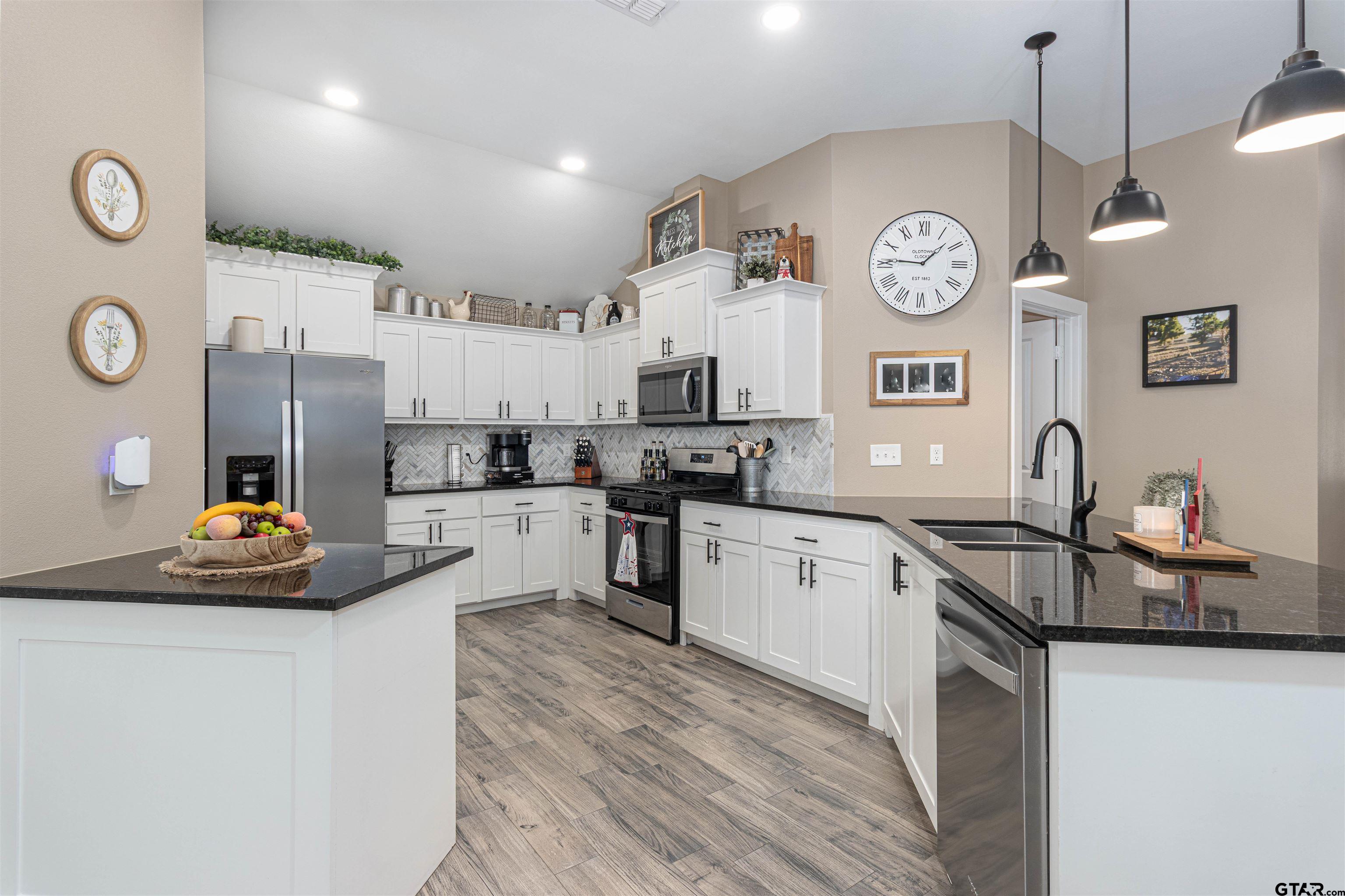 16210 Crossing Circle Lindale, TX 75771 - Photo 3 of 22 a kitchen with cabinets a clock and stainless steel appliances