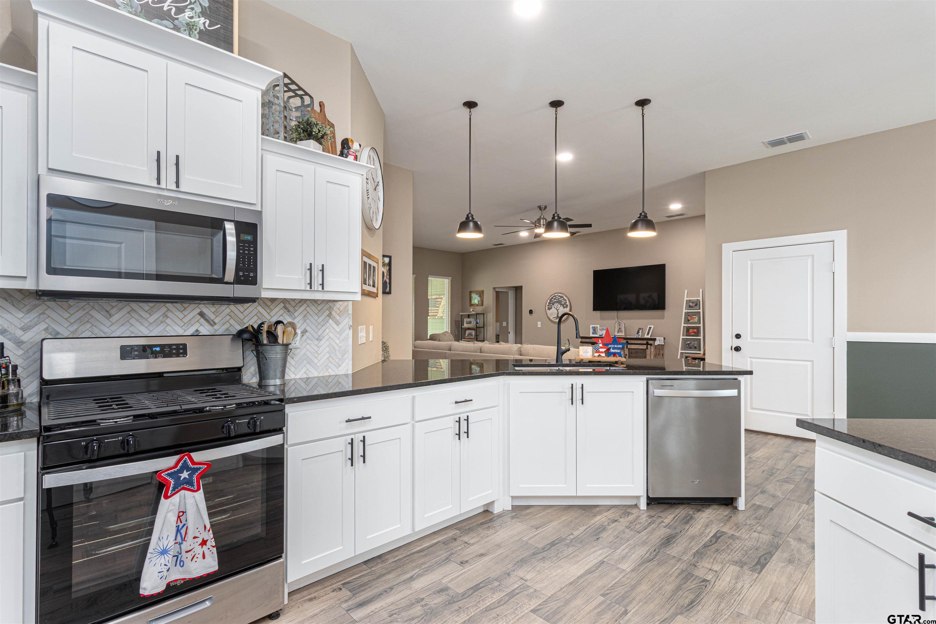 16210 Crossing Circle Lindale, TX 75771 - Photo 5 of 22 a kitchen with stainless steel appliances granite countertop a sink and stove top oven